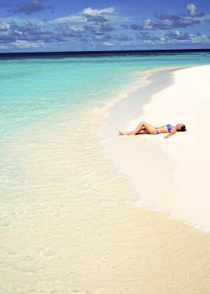 Tourist-sunbathing-on-a-beach-in-Los-Roques-Venezuela-TheGoldenShelter.es